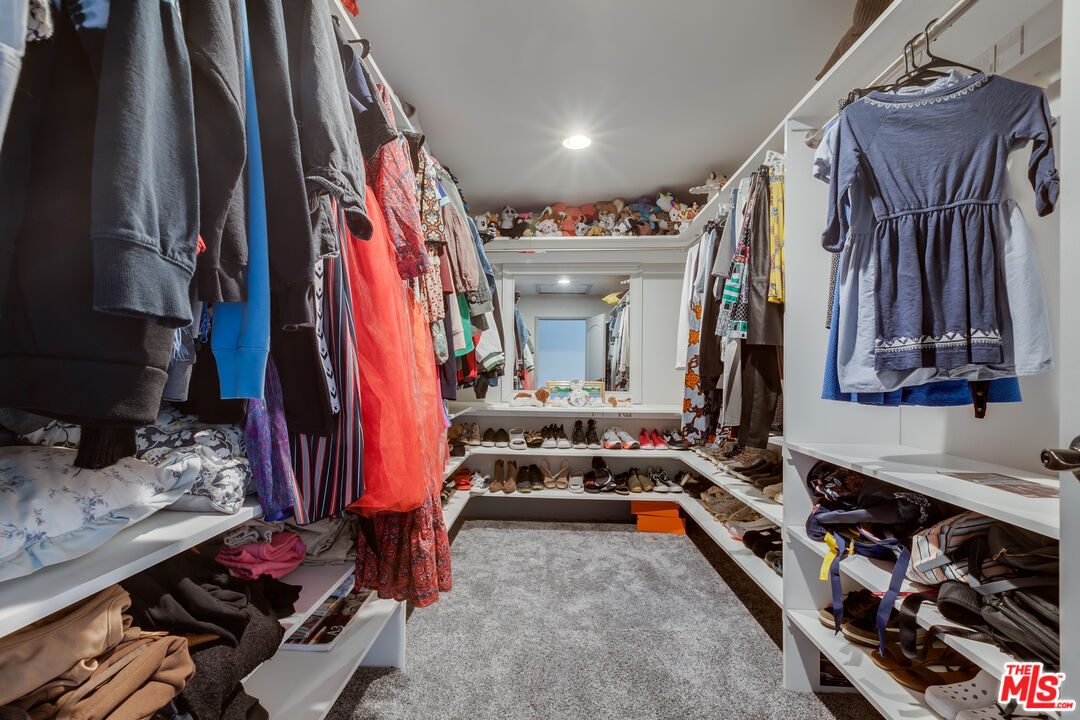17153 Rayen Street Northridge, CA 91325 - Photo 29 of 47 a view of walk in closet with clothes and shoes