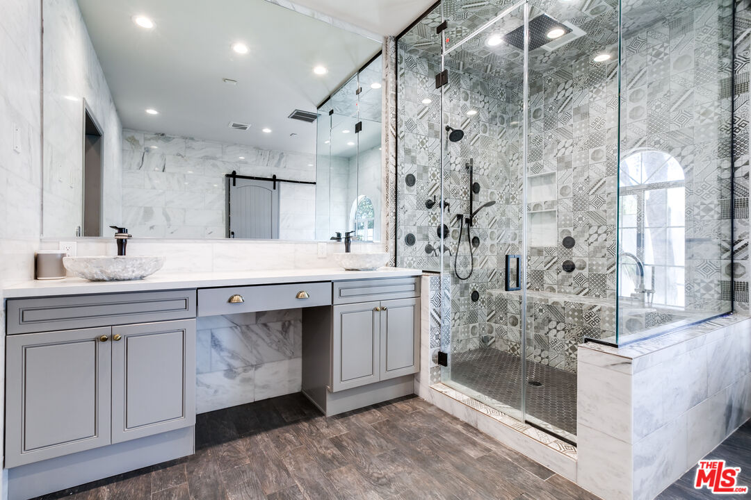 17153 Rayen Street Northridge, CA 91325 - Photo 37 of 47 a bathroom with a double vanity sink mirror and shower
