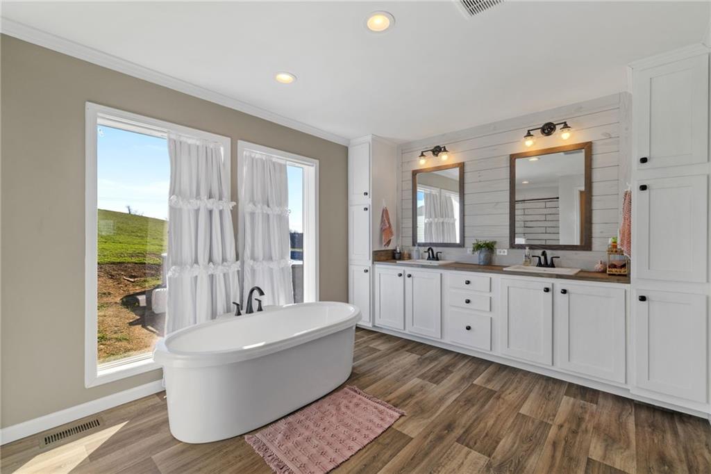 1350 Beham Ridge Road West Alexander, PA 15376 - Photo 27 of 48 a spacious bathroom with a double vanity sink a mirror a bathtub and next to a window