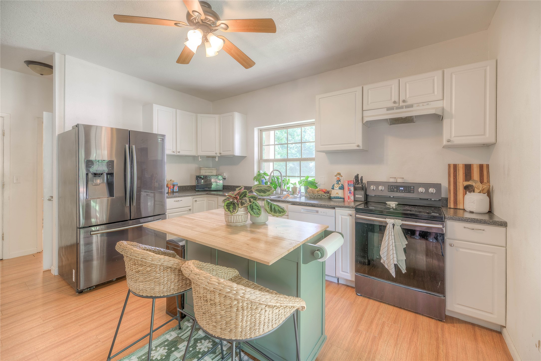110 Happy Trails Road Coldspring, TX 77331 - Photo 21 of 49 a kitchen with stainless steel appliances granite countertop a stove a refrigerator a sink a dining table and chairs with wooden floor