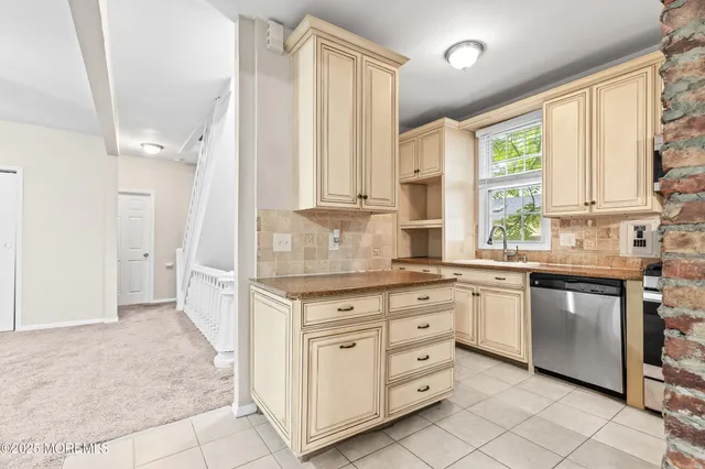 a kitchen with granite countertop a stove a sink and a microwave