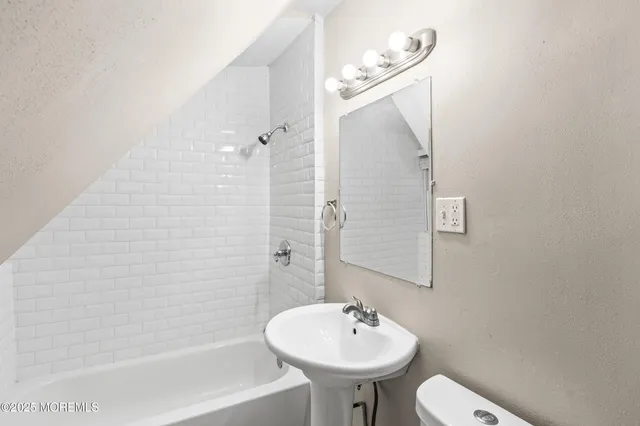 an empty room with wooden floor and ceiling fan