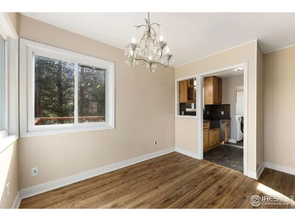a view of a room with wooden floor chandelier and windows