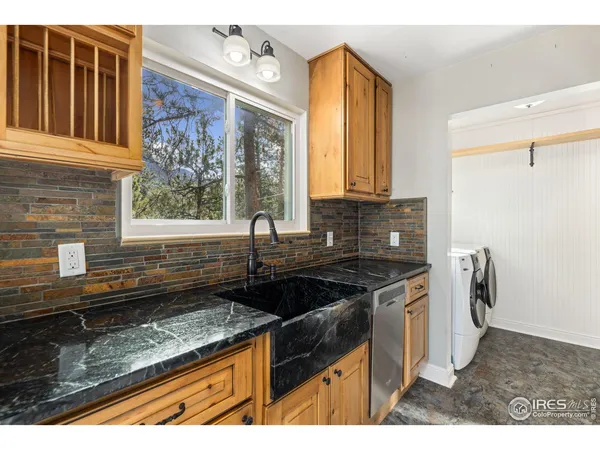 a kitchen with granite countertop a sink a stove and a wooden floor