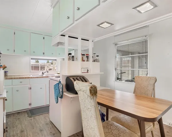 a kitchen with a table chairs and a refrigerator