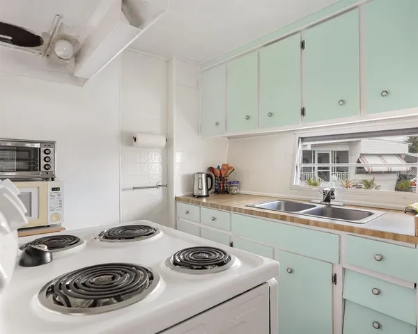 a kitchen with a sink a stove and cabinets