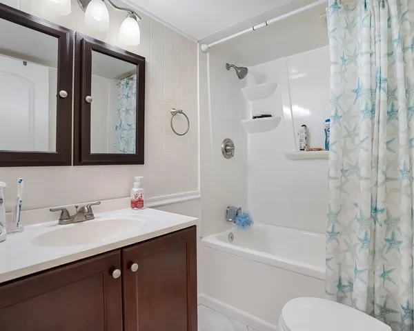 a bathroom with a bathtub sink mirror and toilet