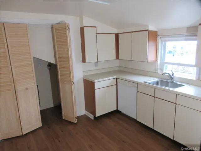 a kitchen with a sink cabinets and wooden floor