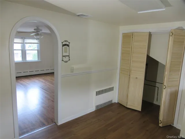 a view of empty room with wooden floor and window