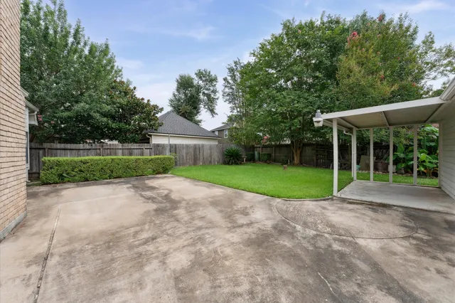 a view of a house with a big yard and potted plants