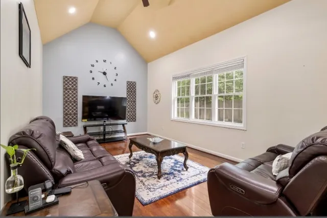 a living room with furniture a flat screen tv and a window