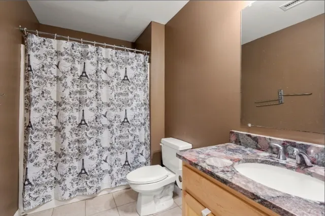 a bathroom with a granite countertop toilet a sink and a mirror