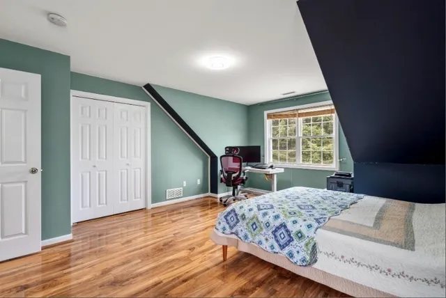 a bed sitting in a bedroom next to a window