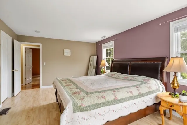 a bedroom with a bed and a dresser with mirror