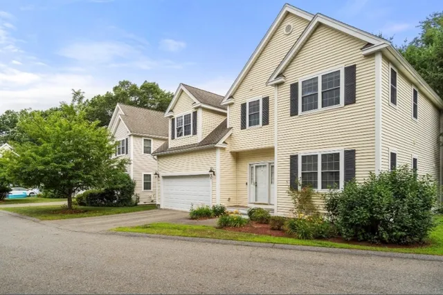 a front view of a house with a yard and trees