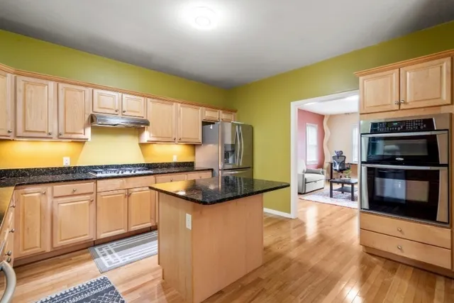 a kitchen with stainless steel appliances granite countertop a stove a sink and a microwave