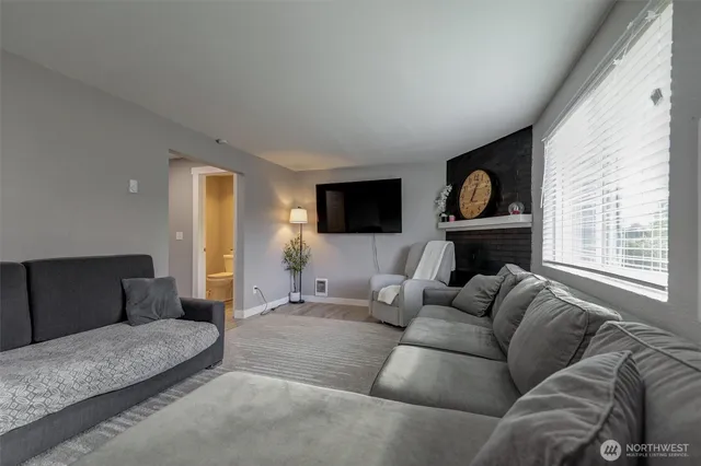 a living room with furniture a flat screen tv and a fireplace