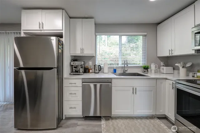 a kitchen with stainless steel appliances granite countertop a refrigerator sink and cabinets
