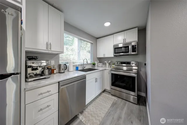 a kitchen with granite countertop white cabinets and appliances