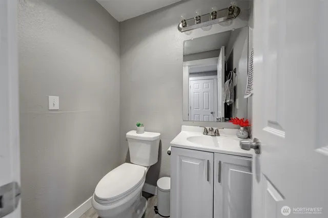 a bathroom with a sink vanity mirror and toilet