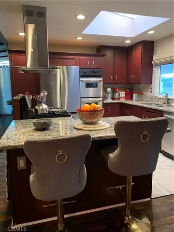 a kitchen with stainless steel appliances granite countertop a sink a stove and a cabinets