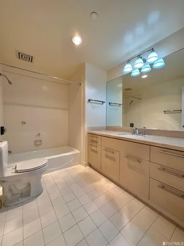 a spacious bathroom with a granite countertop sink a toilet and a bathtub