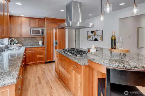 a kitchen with stainless steel appliances granite countertop a sink stove and refrigerator