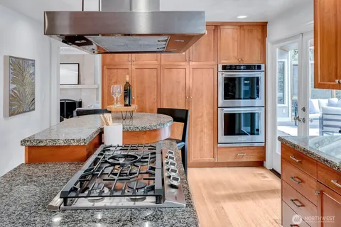 a kitchen with stainless steel appliances granite countertop a stove a sink and a microwave