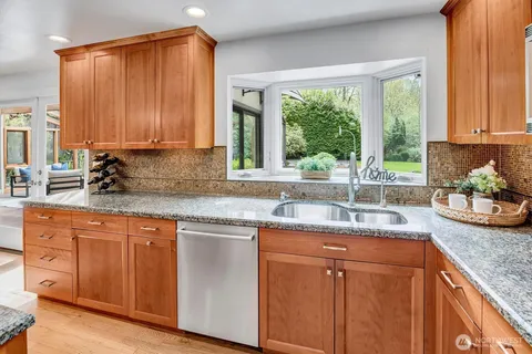 a kitchen with granite countertop white cabinets and a window
