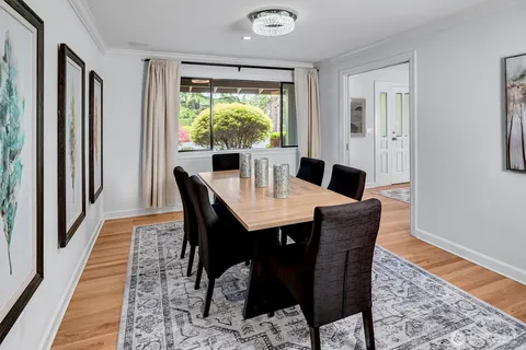 a dining room with furniture a rug and wooden floor