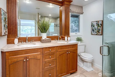 a bathroom with a granite countertop toilet sink and mirror