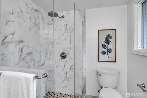 a bathroom with a toilet and a shower