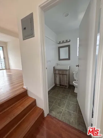 a view of an entryway with wooden floor and a bathroom