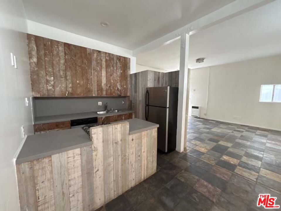 915 Broadway Street, Unit 1 Venice, CA 90291 - Photo 10 of 32 a kitchen with a stove a refrigerator and wooden cabinets