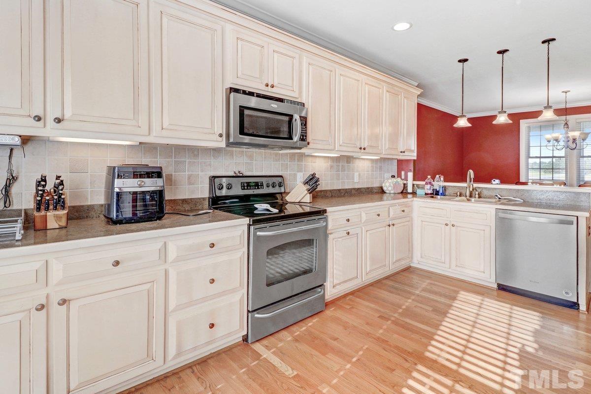 2899 Benson Hardee Road Benson, NC 27504 - Photo 11 of 31 a kitchen with white cabinets stainless steel appliances and sink