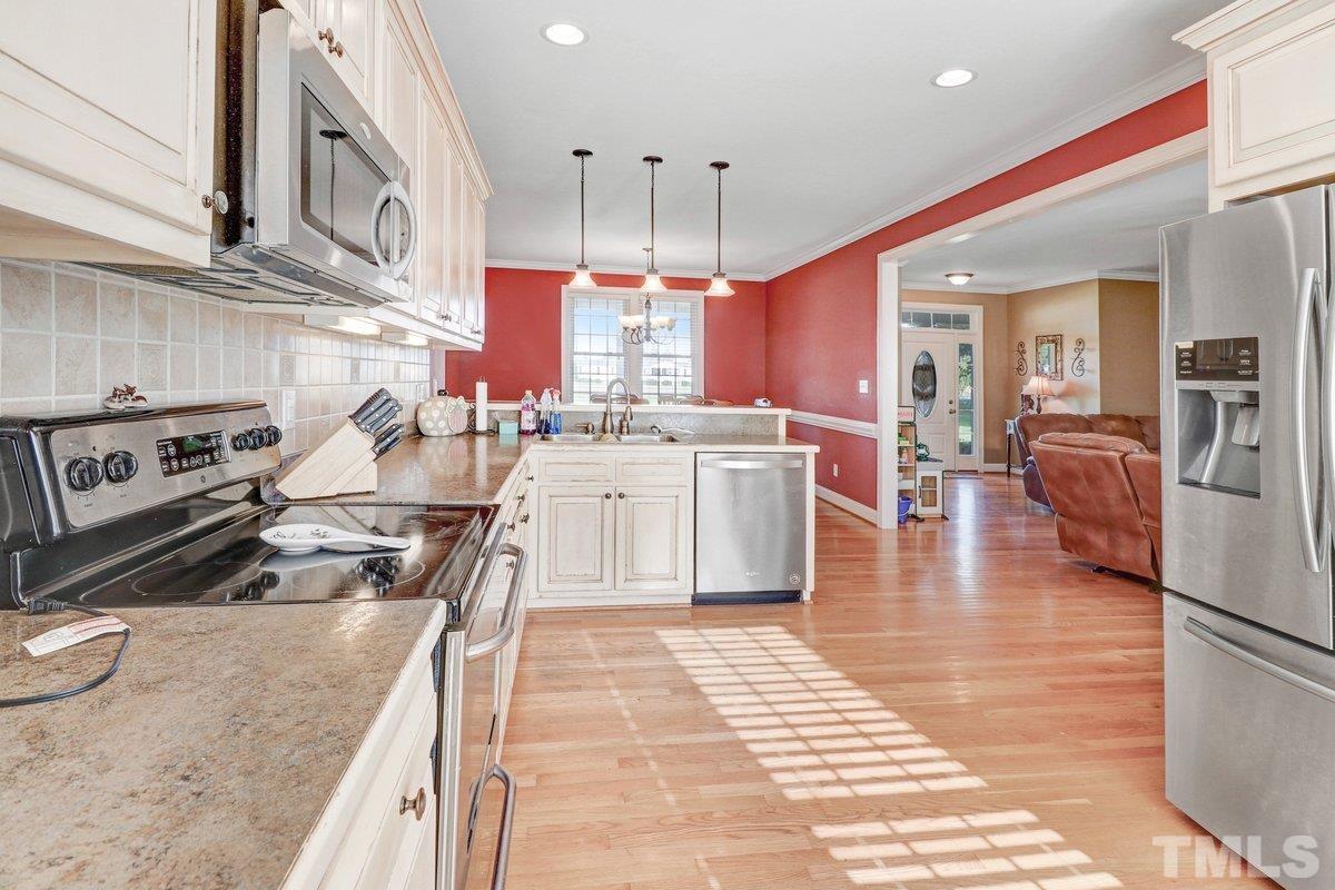 2899 Benson Hardee Road Benson, NC 27504 - Photo 12 of 31 a kitchen with stainless steel appliances granite countertop a stove top oven a sink a counter space and cabinets