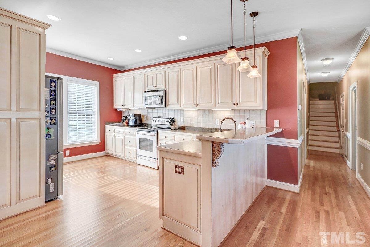 2899 Benson Hardee Road Benson, NC 27504 - Photo 16 of 31 a kitchen with kitchen island granite countertop a sink cabinets and wooden floor