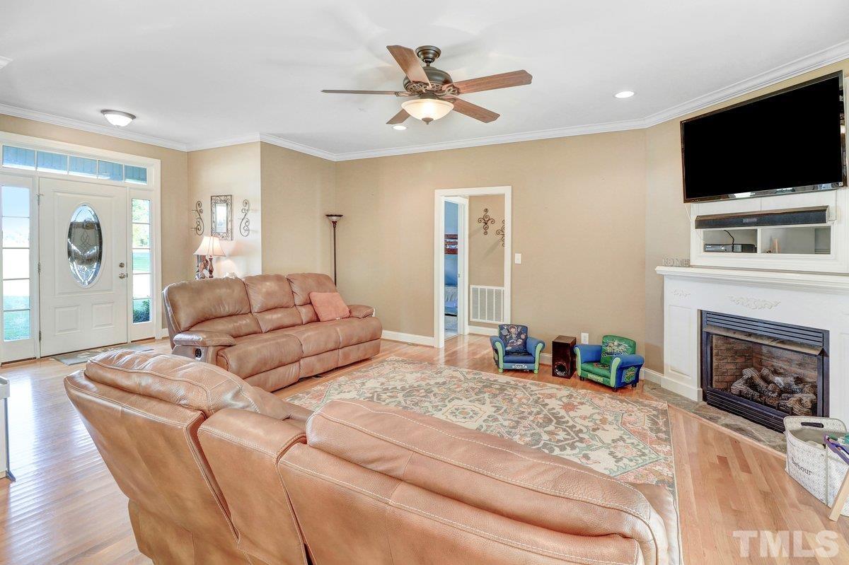 2899 Benson Hardee Road Benson, NC 27504 - Photo 19 of 31 a living room with furniture a flat screen tv and a fireplace