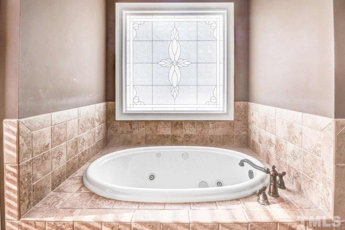 2899 Benson Hardee Road Benson, NC 27504 - Photo 4 of 31 a white bath tub sitting in a bathroom next to a window