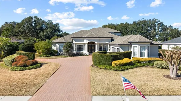 a front view of a house with a yard and potted plants