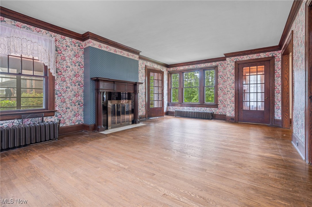 1271 Circle Drive Akron, OH 44310 - Photo 5 of 45 Living room featuring wallpapered walls, molding,light wood finished floors, and a fireplace with flush hearth