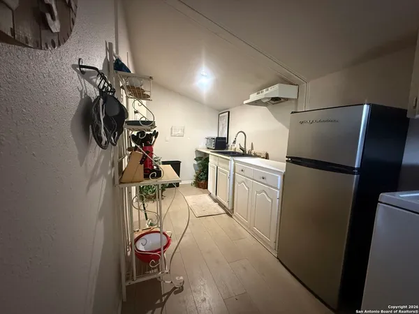 a kitchen with white cabinets and a refrigerator