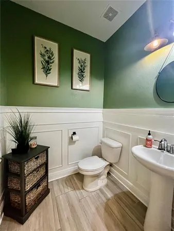 a bathroom with a toilet sink and mirror