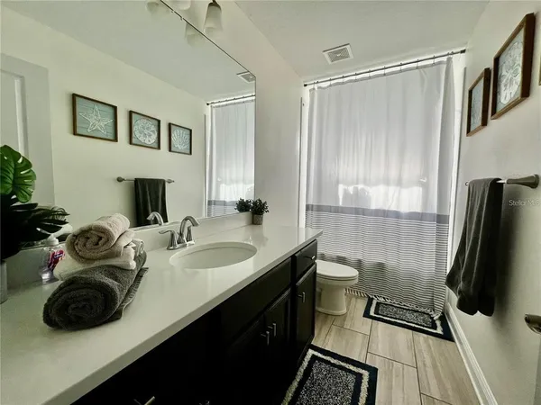 a bathroom with a double vanity sink toilet and mirror
