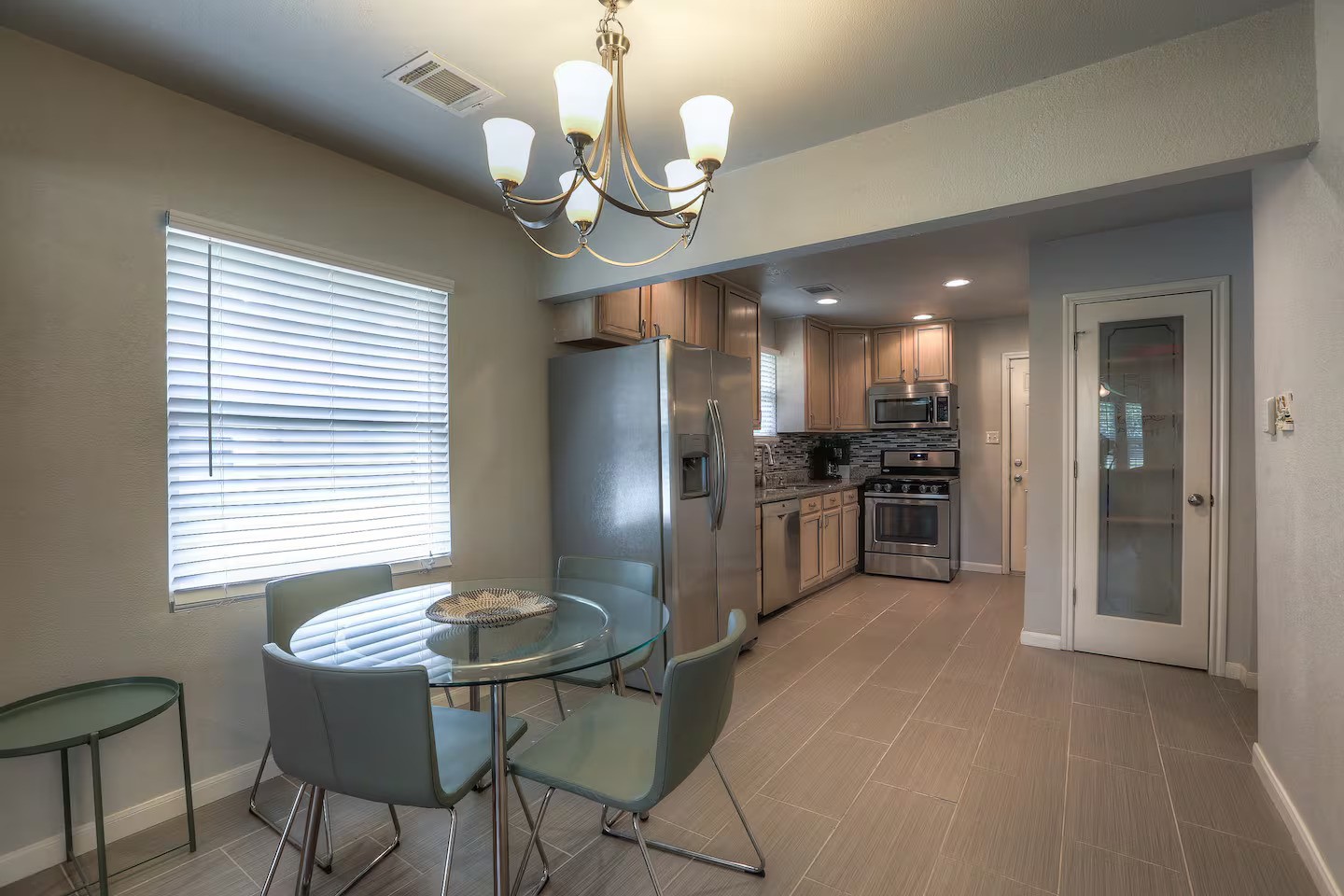 3523 Charleston Street Houston, TX 77021 - Photo 3 of 17 a kitchen with stainless steel appliances kitchen island granite countertop a refrigerator a stove a kitchen island a dining table and chairs
