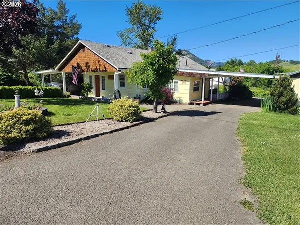 a front view of a house with a yard and potted plants
