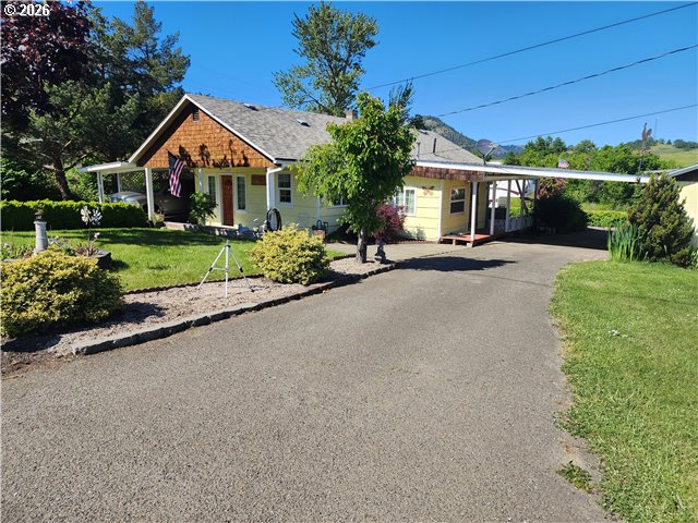 a front view of a house with a yard and potted plants