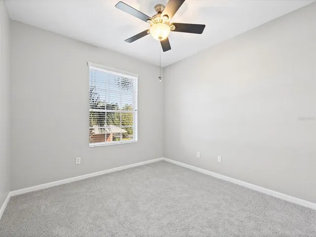 an empty room with chandelier fan
