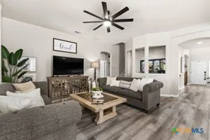 a living room with furniture a flat screen tv and a potted plant