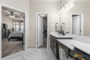 a kitchen with stainless steel appliances granite countertop a stove a sink a microwave a refrigerator and chairs